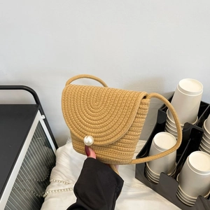 Détail d'un sac en paille tissé à la main avec boucle perle et texture de corde