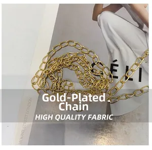 Close-up of a polished gold-plated chain strap on a luxury fashion magazine