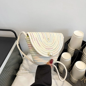 Détail d'un mini sac à bandoulière tissé main avec fermoir perle et motifs arc-en-ciel
