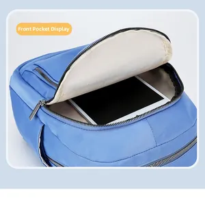 Front pocket detail of blue nylon backpack showing spacious tablet storage compartment