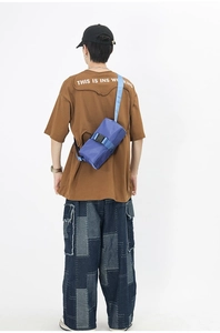 Blue nylon crossbody bag featuring adjustable woven strap and plastic buckle detail