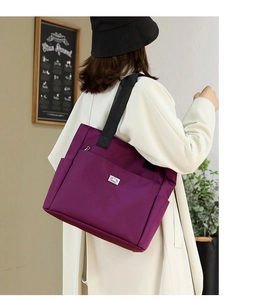 Détail d'un sac cabas en tissu Oxford violet avec logo en métal et fermeture éclair