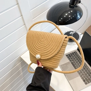 Détail du sac en paille tressée kaki avec boucle en grosse perle et tissage en spirale texturé