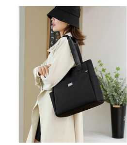 Détail du grand sac cabas noir en tissu Oxford avec logo argenté et bandoulière