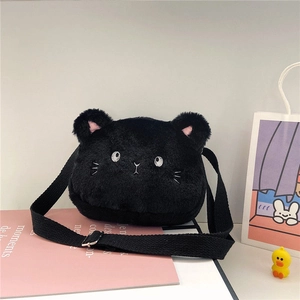 Detalle del bolso de gato de peluche negro con bordados blancos y correa ajustable de moda