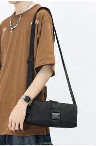 Detail shot of black Oxford fabric crossbody bag with adjustable strap and buckle closure