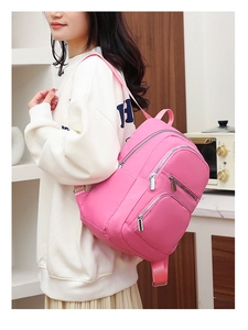 Side view of model wearing a stylish pink high-density nylon backpack with large capacity