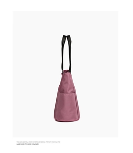 Détail du sac fourre-tout en tissu Oxford rose avec anses noires et poche avant