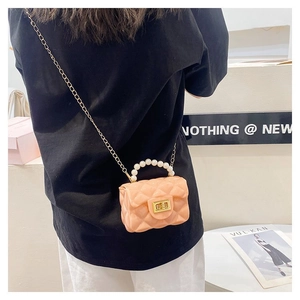 Detailed back view of a peach quilted jelly mini bag with pearl handle and gold chain