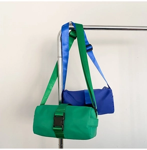 Detail view of cylinder oxford bags in emerald green and royal blue with buckle straps