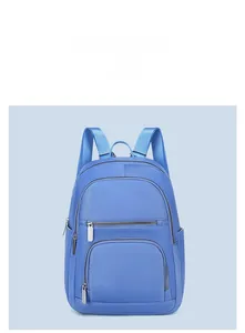 Detail view of sky blue backpack with multiple compartments and smooth matte texture