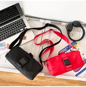 Detail view of small nylon crossbody bags with buckle strap in black and red colors