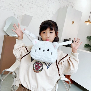 Detalle de bolso de gato de peluche blanco con correa ajustable en una niña modelo