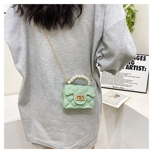 Detail of light green quilted jelly bag with pearl handle and golden metal turn-lock