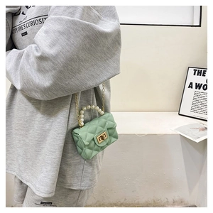 Mint green quilted mini jelly bag with pearl handle and chain strap on a model