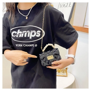 Detail of mini black quilted chain bag with pearl handle and golden twist lock closure