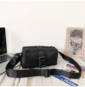 Detail view of black oxford nylon crossbody bag with adjustable wide strap and buckle strap