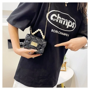 Detail of black quilted mini bag with glossy patent finish and elegant pearl handle