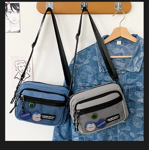 Detail of trendy canvas crossbody bags with front mesh pocket and adjustable straps