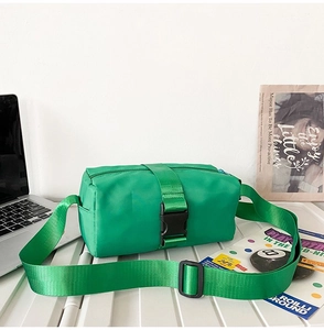 Detail of bright green waterproof nylon crossbody bag with wide strap and buckle closure