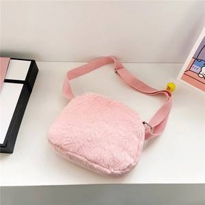 Detalle de bolso de peluche rosa con textura suave y hebilla de correa ajustable