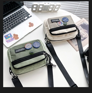 Close-up of minimalist canvas crossbody bags with mesh pocket and colorful badge details