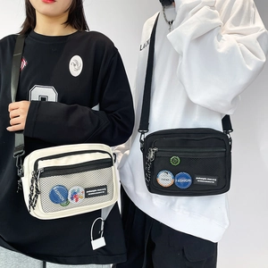 Detail view of canvas messenger bags with mesh pocket and badges for men and women