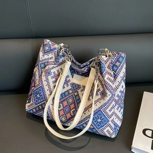 Detail of colorful geometric woven tote bag with premium faux leather straps and logo patch