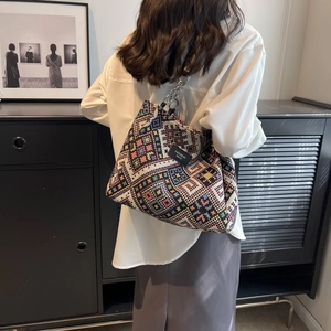 Detail of bohemian geometric pattern on a large woven tote bag with chain strap