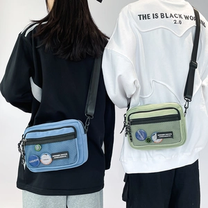Detail of canvas messenger bag with mesh front pocket and adjustable shoulder strap