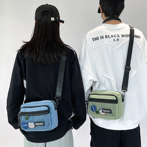 Detail of blue and green nylon crossbody bags with functional mesh pockets and logo