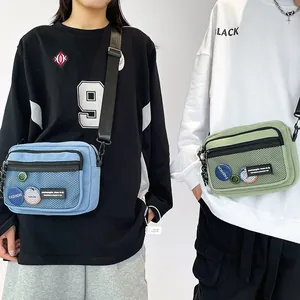 Detail view of Japanese-style canvas crossbody bags in light blue and green with mesh pockets