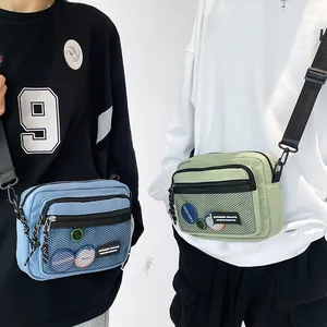 Detail of blue and green nylon crossbody bags with front mesh pocket and adjustable strap