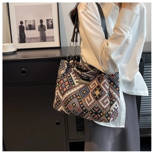 Detail view of ethnic geometric pattern tote bag with leather straps and metal chains