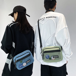 Detail of blue and green crossbody bags with nylon mesh pockets and decorative badges