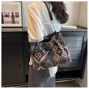Detail of bohemian large capacity woven tote bag with colorful geometric patterns and leather strap