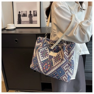 Detail of multi-color woven tote bag with geometric ethnic pattern and leather handle