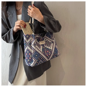 Detail of bohemian knitted tote bag with geometric patterns and chain strap