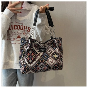 Close-up of geometric ethnic pattern weaving and leather brand label on large tote bag