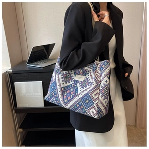 Close-up of woven tote bag with colorful geometric patterns and fashion label details