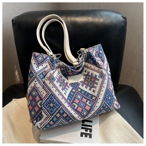 Detail of ethnic geometric woven pattern tote bag with leather handles and silver chain