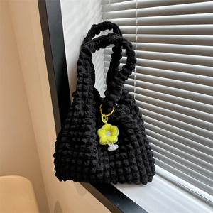 Large black bubble textured tote bag with a yellow flower charm for daily commuting
