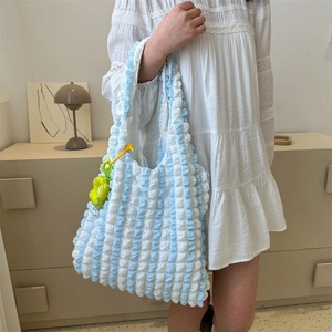Fashionable blue and white striped tote bag with yellow flower charm for daily commute