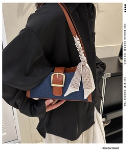 Détail du sac bandoulière en denim avec bordure en cuir, boucle dorée et foulard en soie