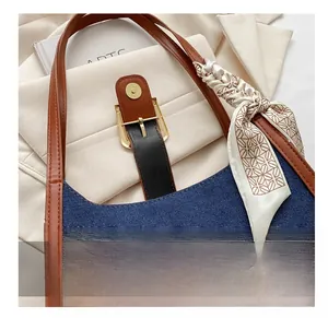 Détail du sac bandoulière en denim bleu avec fermoir magnétique doré et foulard en soie