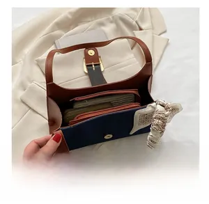 Détail macro de l'intérieur spacieux en denim et cuir contenant un portefeuille et pochette