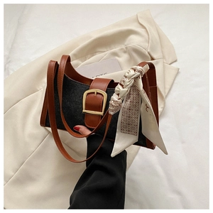 Détail du sac hobo en cuir marron et denim noir avec un foulard décoratif en soie