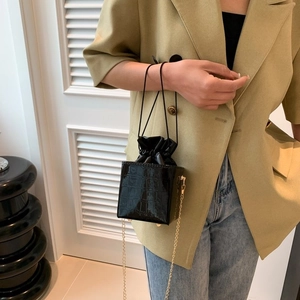 Mini borsa a secchiello a scatola nera con motivo coccodrillo e catena su modella