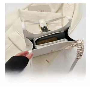 Macro view of white quilted shoulder bag interior showing large capacity for essentials