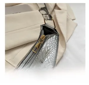 Detailed macro view of smooth golden metal zipper on embossed silver leather bag